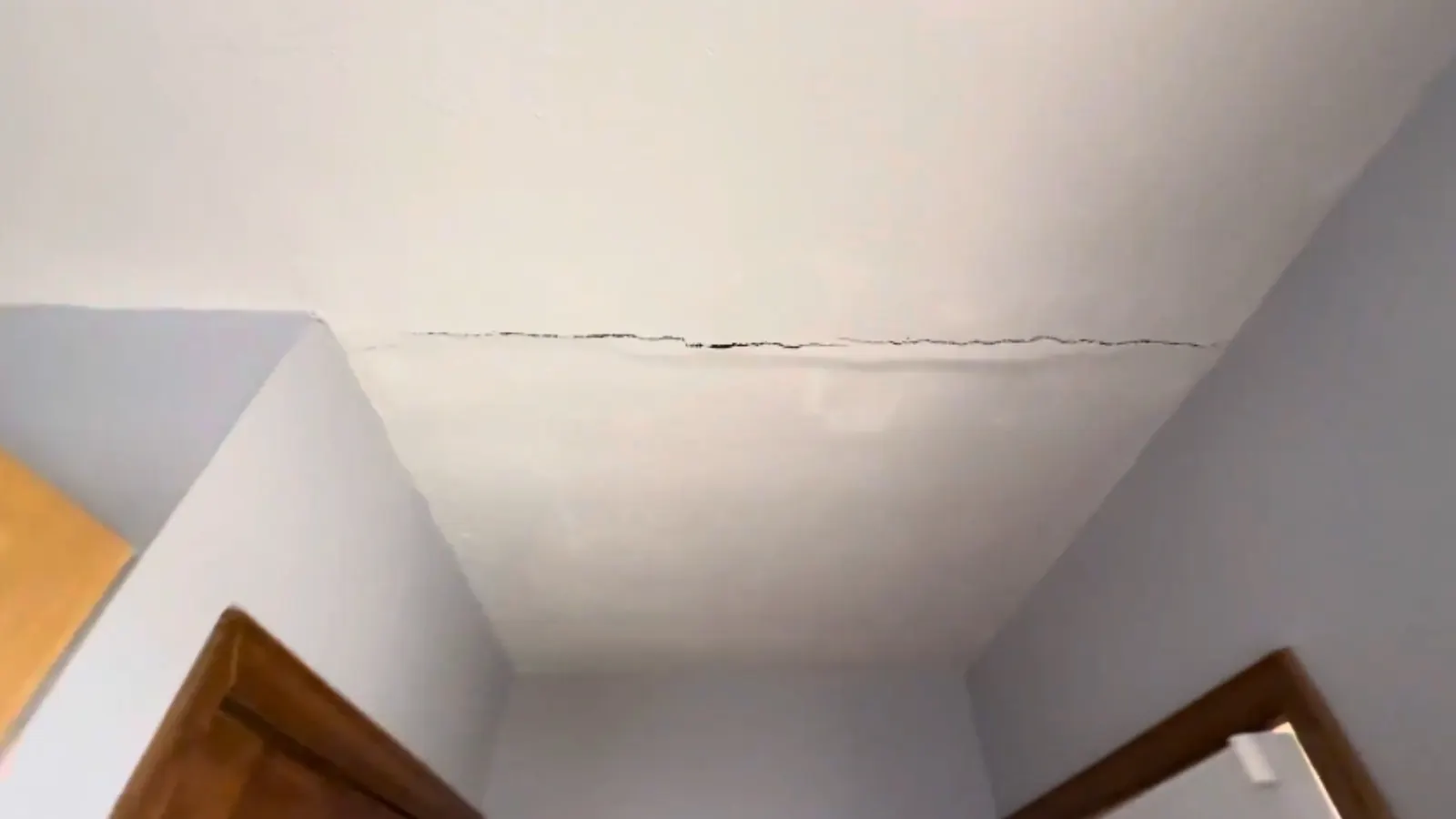 Cracked and stained drywall ceiling from a plumbing leak above