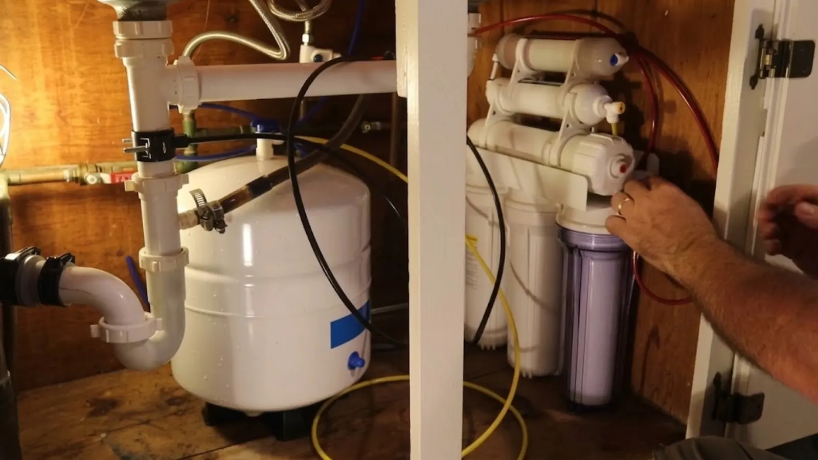Under-sink reverse osmosis filter system being installed in a cabinet